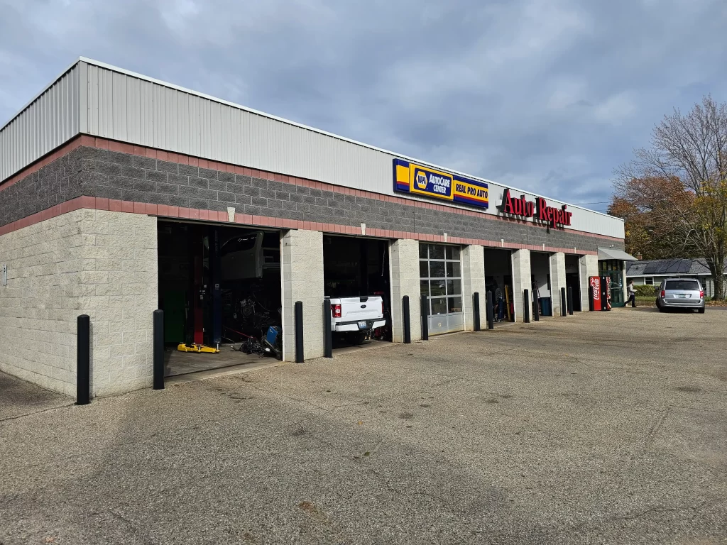 Exterior of Real Pro Auto, a NAPA AutoCare Center, with open garage bays and parked vehicles.