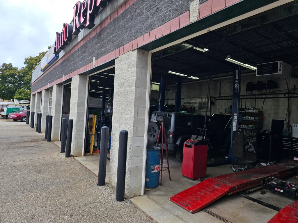 Real Pro Auto repair bays with open garage doors, vehicles inside, and equipment visible outside.