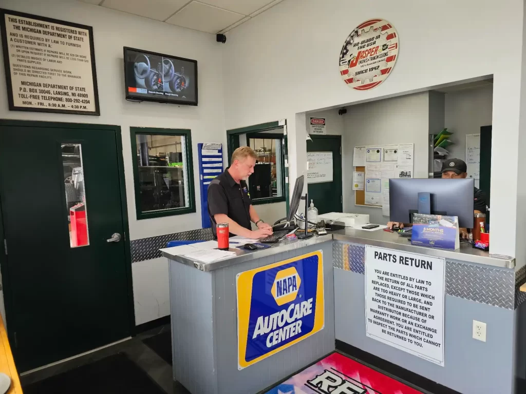 Customer service area at NAPA AutoCare Center with workers, signs, and a "Parts Return" notice.