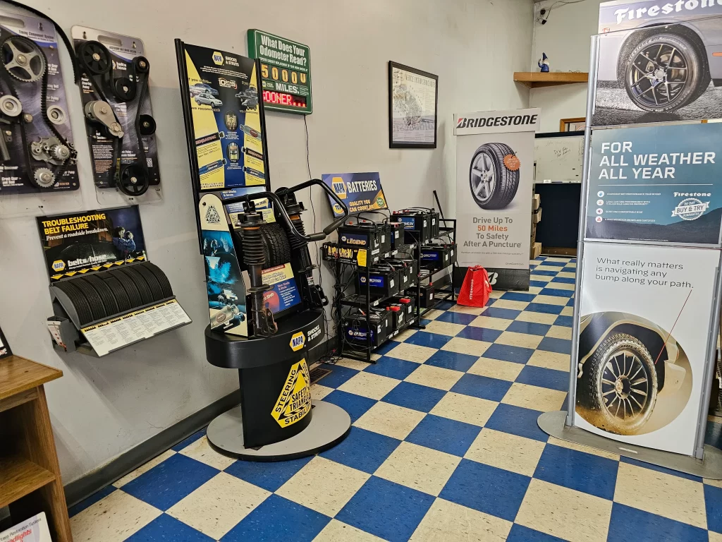 Real Pro Auto shop display with car belts, batteries, and promotional banners on a blue-and-white checkered floor.