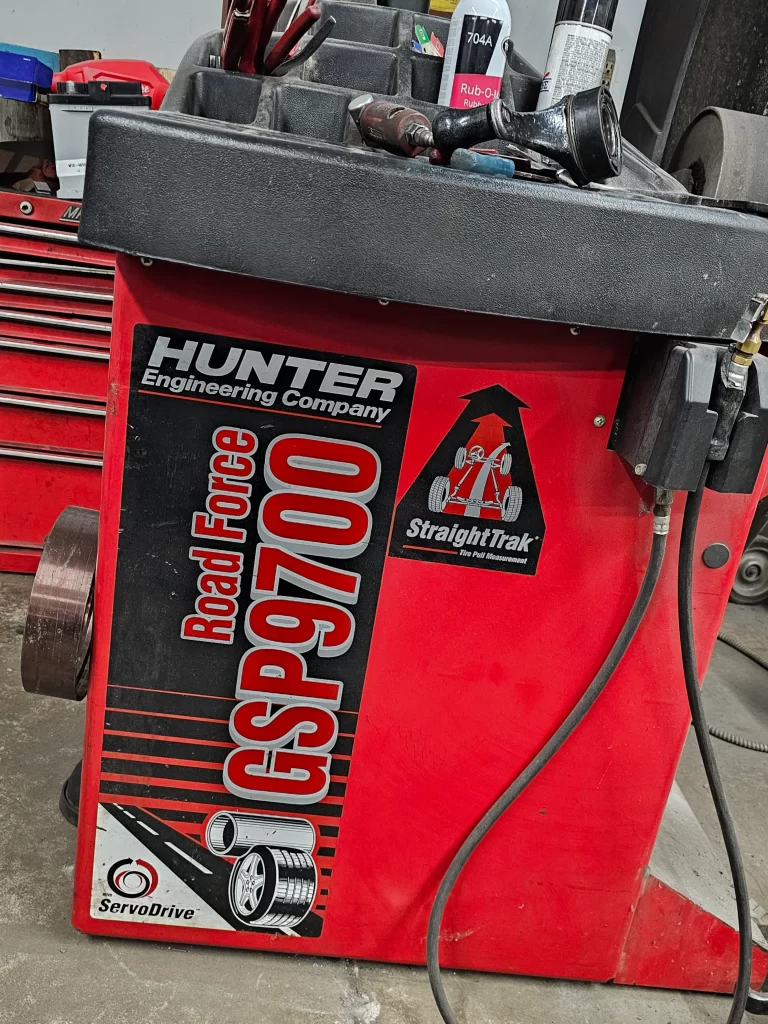 Hunter GSP9700 Road Force tire balancer with tools and equipment on top.