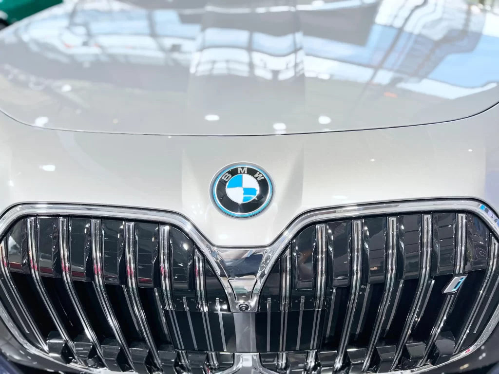 Close-up of a BMW logo and front grille on a sleek silver car.