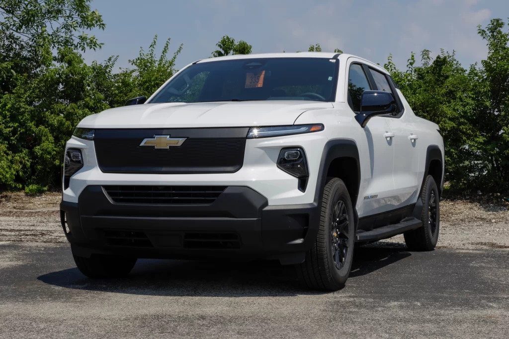 Front view of a white Chevrolet pickup truck parked outdoors on a sunny day.