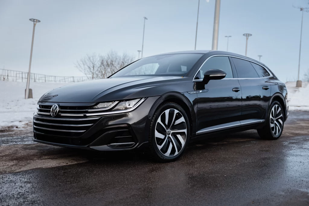 Black Volkswagen sedan parked on a snowy day, representing VW mechanics at Real Pro Auto.